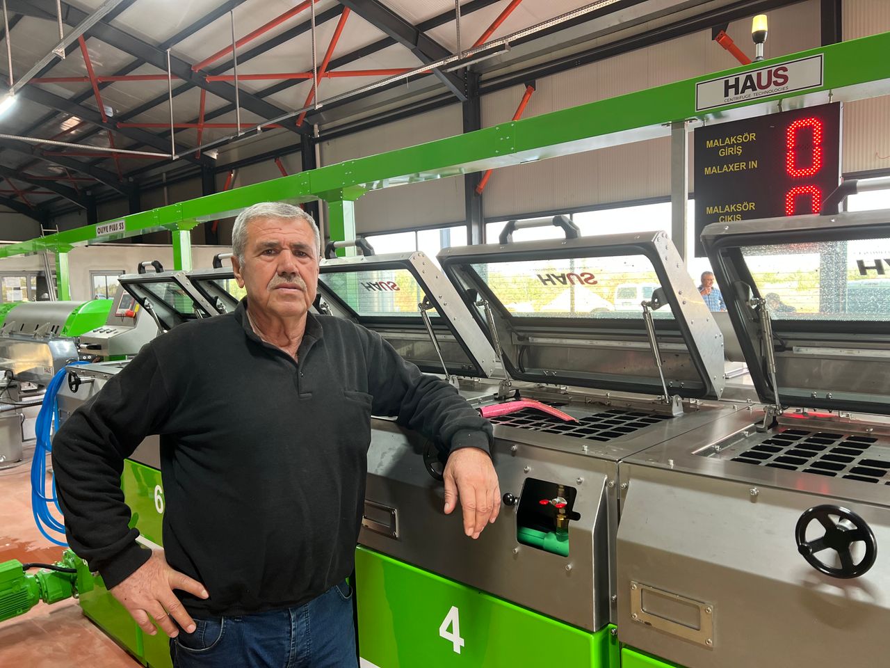 Kurucumuz Ali Batu, fabrikadaki üretim makineleri önünde